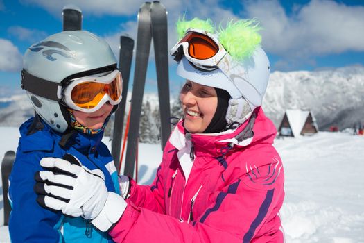 Happy little boy to ski in ski goggles and a helmet with his mother