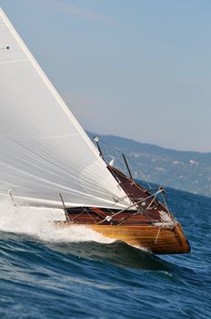 Bow of a sailing boat over the blue waves