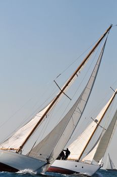 Two yachts engaged in a sailing race with another in background