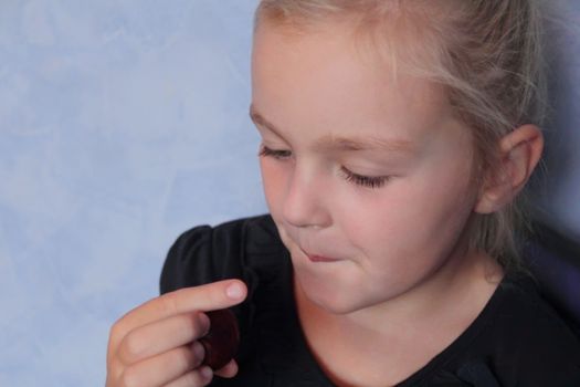 Portrait of beautiful small girl eating sweetmeat