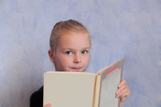 Portrait of girl with blond hair reading a book