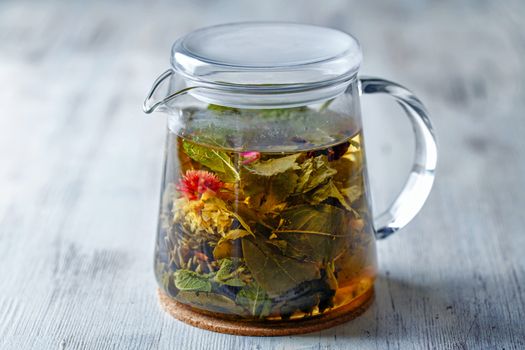 Glass tea kettle on the wooden table closeup shot