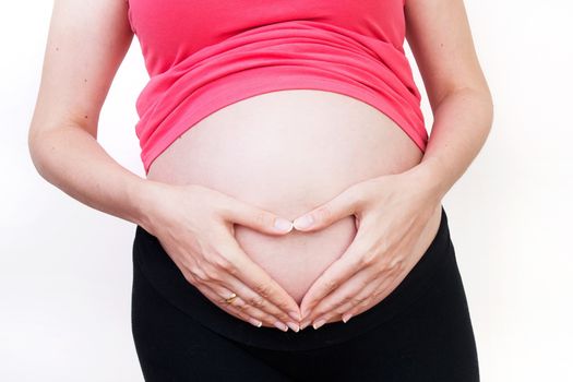 Pregnant woman making heart shape from hands