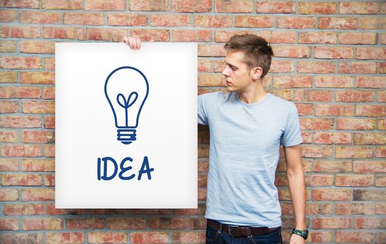 Young man holding whiteboard with idea bulb
