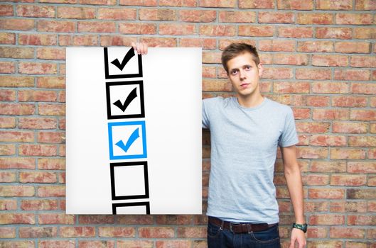 Young man holding whiteboard with check boxes