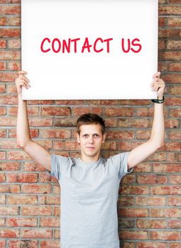 Young man holding whiteboard with contact us words