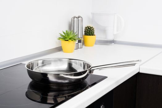 Frying pan in modern kitchen with induction stove