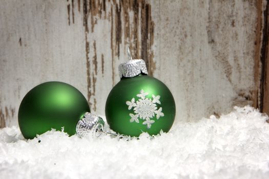 christmas decoration with wooden background, snow, christmas baubles green 