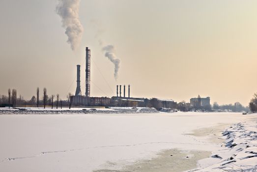 Power station in winter by a frozen river