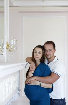 Happy beautiful pregnant woman with his husband at home