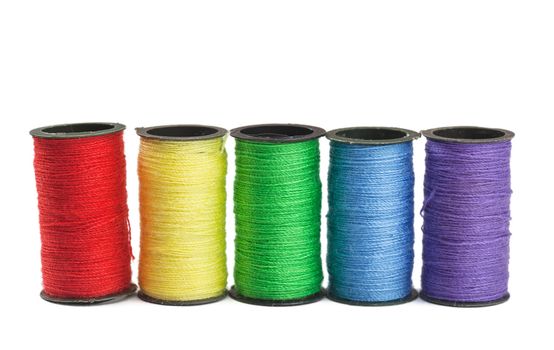 Colorful spools with green, blue, yellow and red threads
