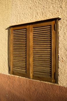 Mediterranean window with traditional closed wooden shutters