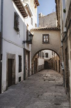 Typical Street of the world heritage city in Baeza, Street Barbacana next to the clock tower, It is characterized by the union of two houses with a passage, Baeza, Jaen province, Andalucia, Spain