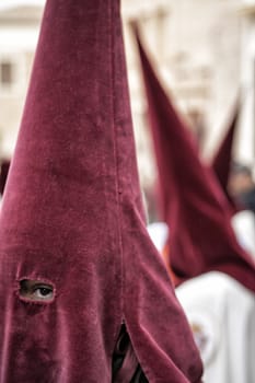 Detail penitent with red caperuz in Holy Week, Spain