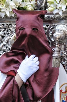 Nazarene that goes with the hand on the manigueta the throne in a procession of holy week. Not wearing capirote, and the mask falls loose by the head, back, like the penitents, Spain
