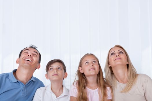 Portrait Of  Family With Two Children Looking Up, Indoors