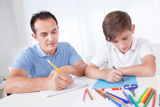 Father And Son Drawing Together With Colorful Pencils And Crayons At Home