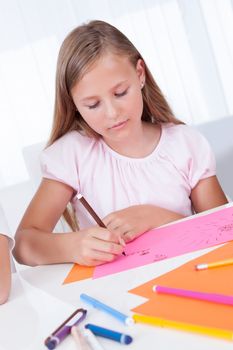 Portrait Of Girl Drawing With Colorful Markers At Home