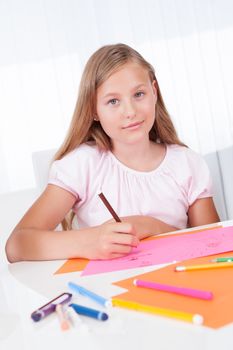 Portrait Of Girl Drawing With Colorful Markers At Home