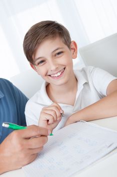 Portrait Of Son Doing Homework At Home