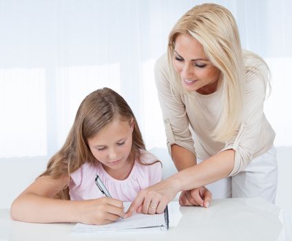 Mother Helping Her Daughter With Homework At Home