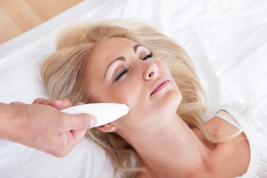 Profile View Of Happy Young Woman During Cosmetic Treatment, Indoors