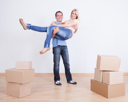 Portrait Of Husband Holding Wife In New Home, Indoors