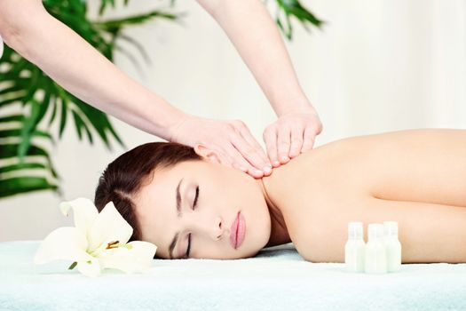 Brunette woman on neck massage in spa center