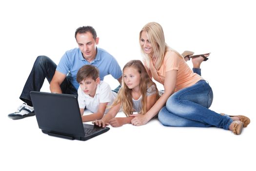 A Happy Family With Two Children Using Laptop Isolated On White Background