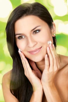 Closeup up of a young woman applying beauty product