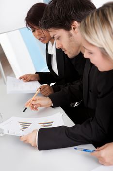 Group of business people looking at charts in the meeting