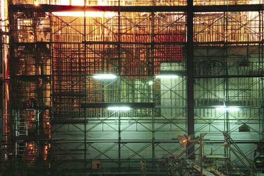 highly-detailed construction site by night with many metallic frames