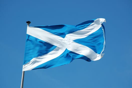 Waving in the blue sky flag of Scotland