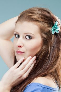 portrait of a young beautiful woman with brown hair - isolated on blue