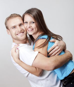 portrait of a happy young couple smiling, looking - isolated on gray