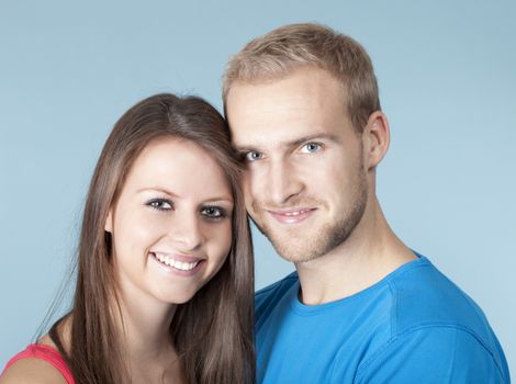 portrait of a happy young couple smiling, looking - isolated on blue