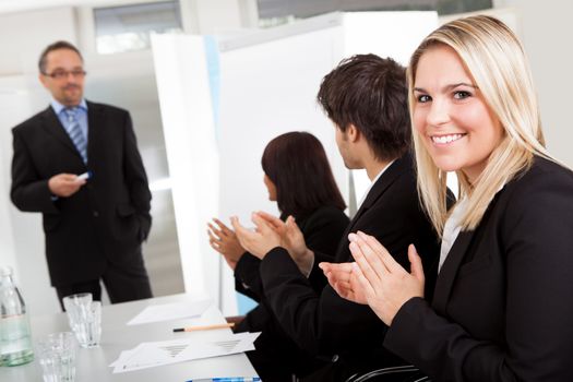 Portrait of businesswoman at presentation applauding to the lecturer