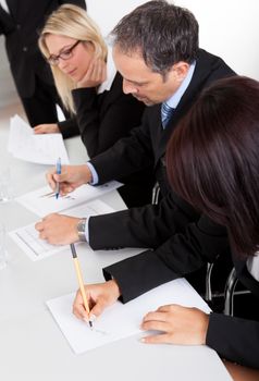 Group of business people taking notes at the meeting