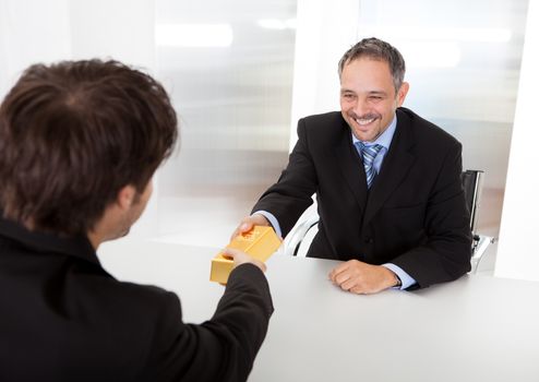 Portrait of happy businessman receiving gold bar