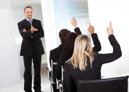 Group of successful business people at the lecture asking questions