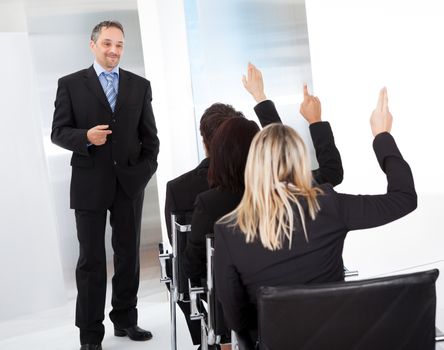 Group of successful business people at the lecture asking questions