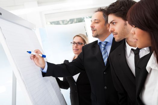 Group of business people looking at the graph on flipchart