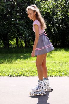 Happy young woman enjoying roller skating rollerblading on inline skates sport in park. Woman in outdoor activities