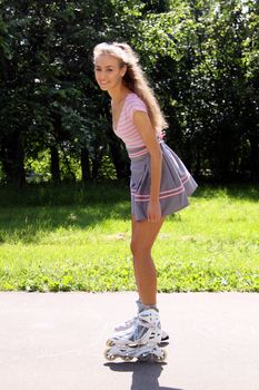 Happy young woman enjoying roller skating rollerblading on inline skates sport in park. Woman in outdoor activities