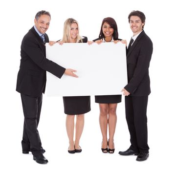 Group of happy business colleagues holding billboard isolated on white background