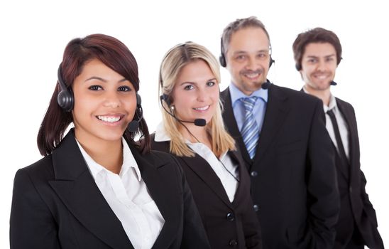 Confident business team with headset standing in a line against white background