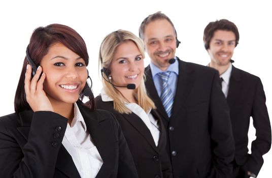 Confident business team with headset standing in a line against white background