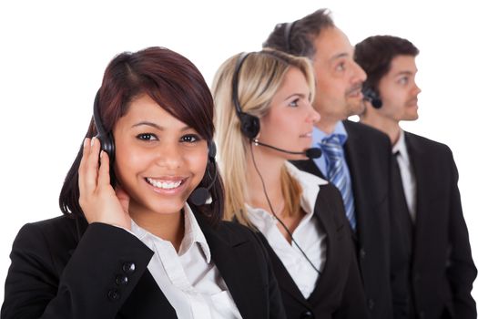 Confident business team with headset standing in a line against white background