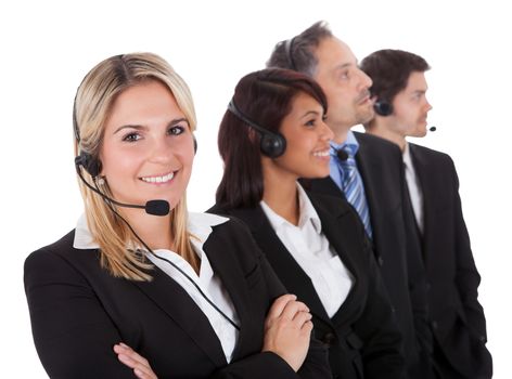 Confident business team with headset standing in a line against white background