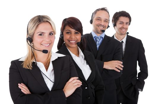 Confident business team with headset standing in a line against white background